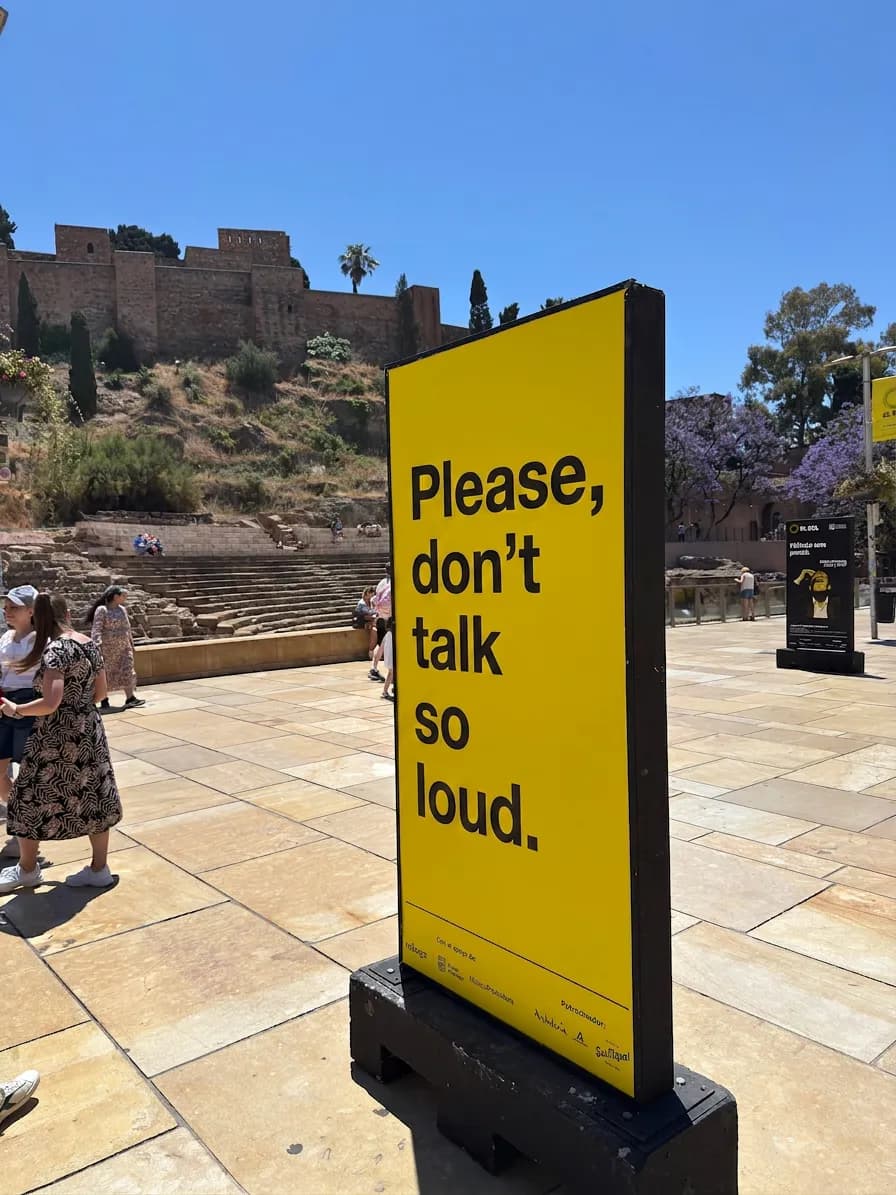A sign reading "Please, don't talk so loud" in Calle Alcazabilla, Málaga.