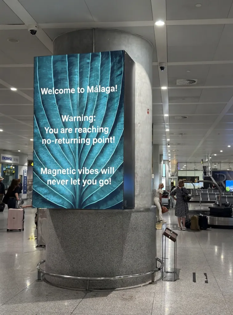 A sign at Málaga Airport (AGP) reading "Warning: magnetic vibes".
