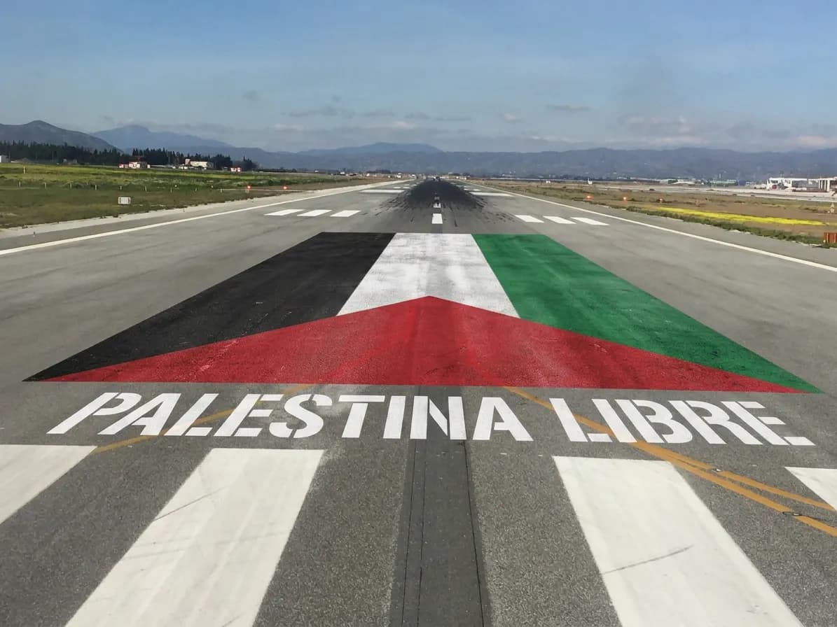 A large Palestinian flag painted across the runway at Málaga airport, with "PALESTINA LIBRE" in white stenciled letters resembling runway markings.