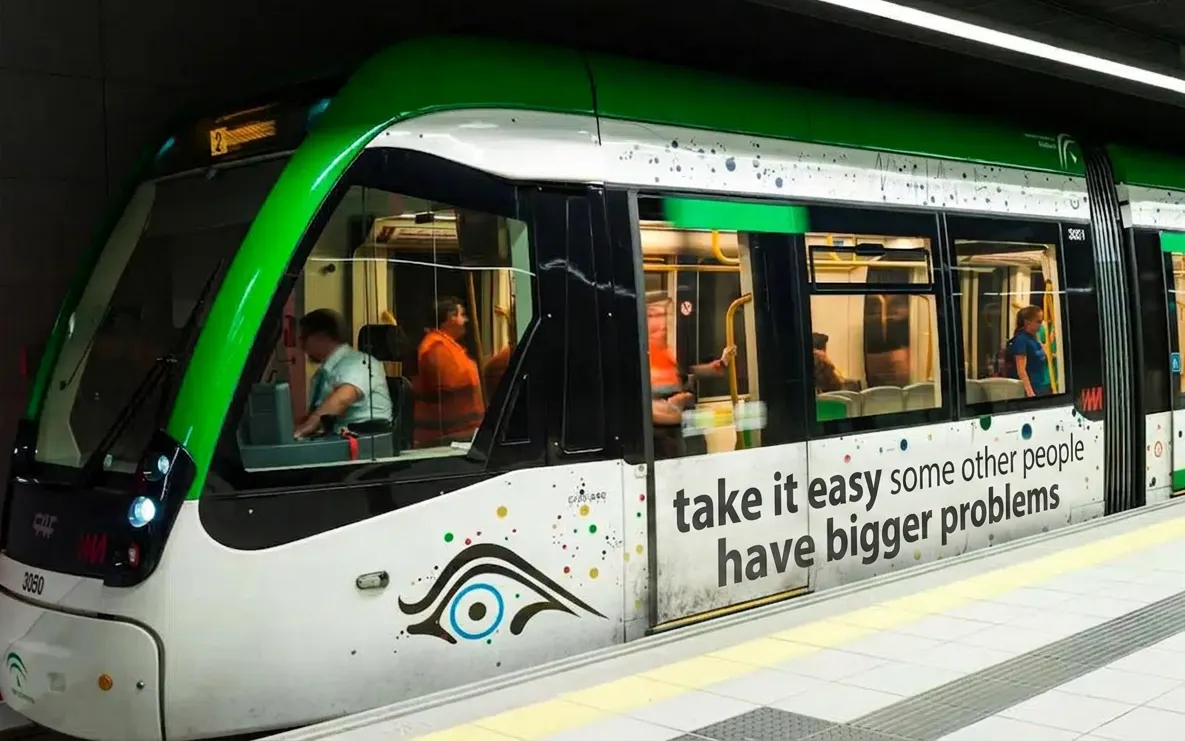 A sign at the Málaga metro reading "Take it easy some other people have bigger problems"