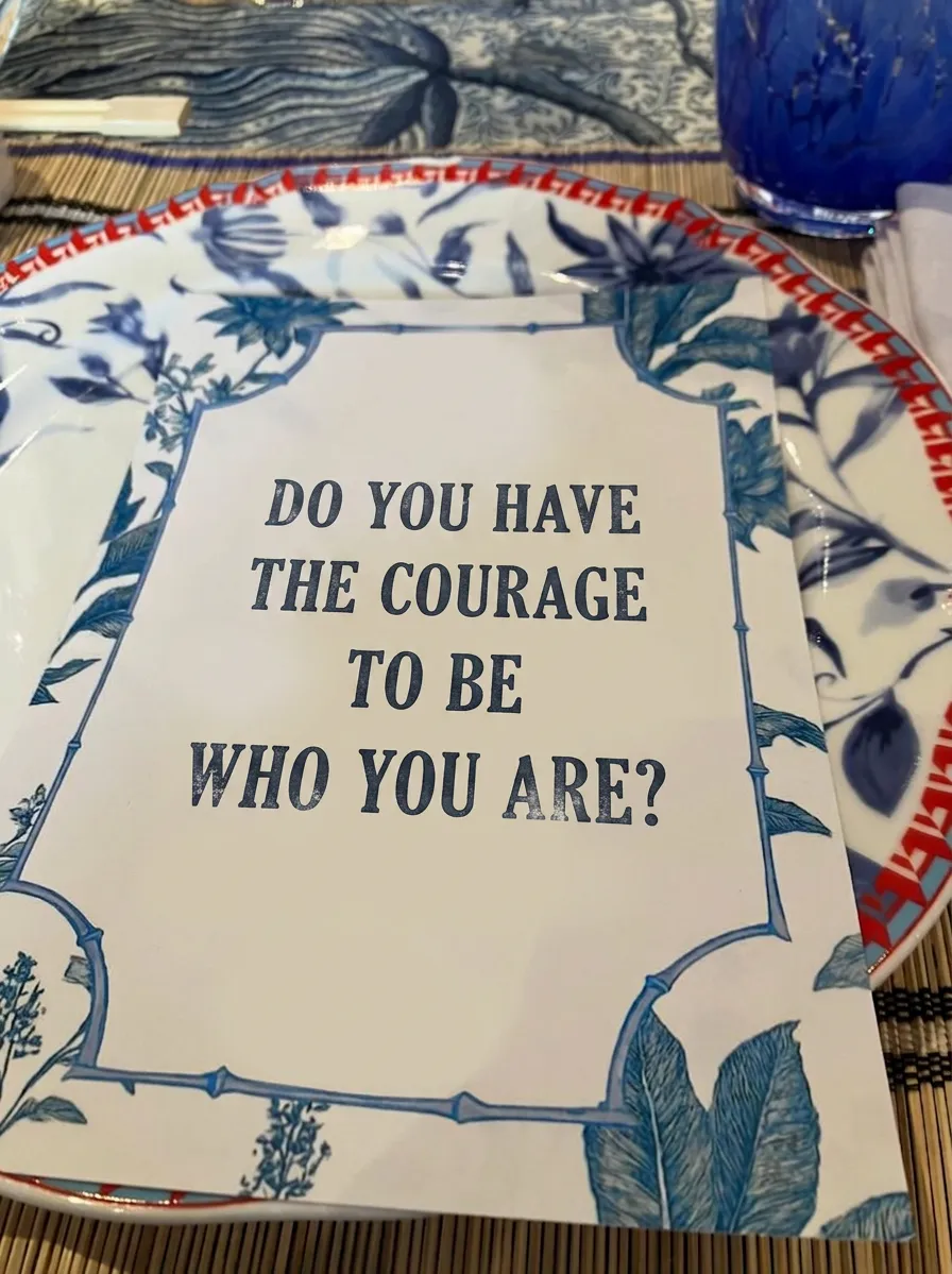 A menu on a restaurant table reading "Do you have the courage to be who you are?"
