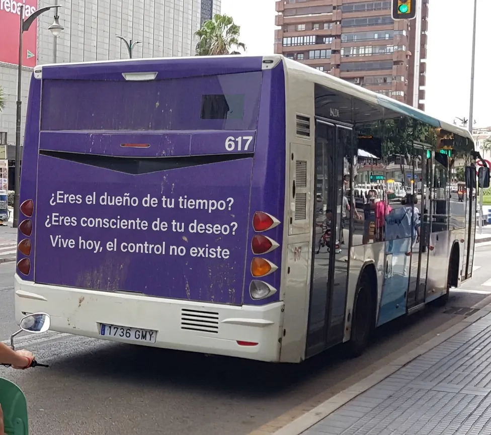 Un cartel en la parte trasera de un autobús de Málaga que dice "¿Eres el dueño de tu tiempo? ¿Eres consciente de tu deseo? Vive hoy, el control no existe."